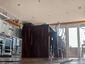 a kitchen with a counter with a bunch of stools at Hobland Barn in Paston