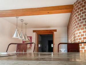 a dining room with a table and a brick wall at Hobland Barn in Paston