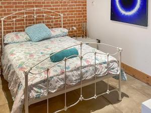 a metal bed in a room with a brick wall at Hobland Barn in Paston +17 photos