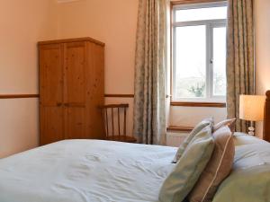a bedroom with a bed and a window at Linhay - Ukc4242 in Lanreath +12 photos