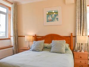 a bedroom with a bed with two lamps and a window at Linhay - Ukc4242 in Lanreath