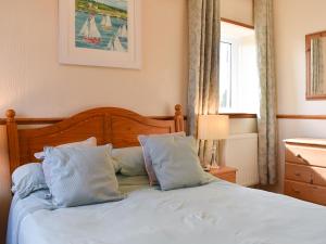 a bedroom with a bed with white sheets and pillows at Linhay - Ukc4242 in Lanreath
