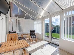 a screened in porch with a table and chairs at Sandbanks in Bacton