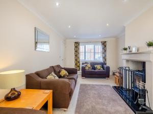 a living room with two couches and a fireplace at Sandbanks in Bacton