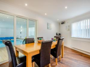 a dining room with a wooden table and chairs at Sandbanks in Bacton