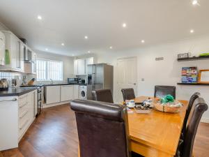 a kitchen with a wooden table and a dining room at Sandbanks in Bacton