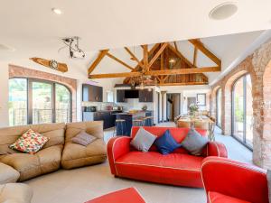 a living room with a red couch and a kitchen at Go Cart Barn in Gloucester
