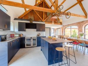 a large kitchen with blue cabinets and a table at Go Cart Barn in Gloucester +22 photos