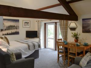a bedroom with a bed and a desk with a television at Barn Owl Bothy in Westward