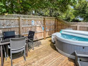 a patio with a hot tub and a table and chairs at Barn Owl Bothy in Westward +3 photos