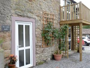 a building with a door and a balcony on it at Barn Owl Bothy in Westward