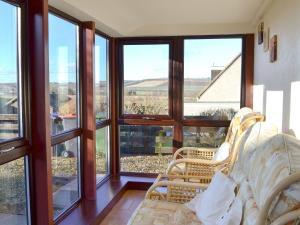 a living room with large windows and a couch at Eliza Cottage in Haddington