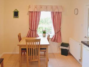 a kitchen with a table and chairs and a window at Eliza Cottage in Haddington