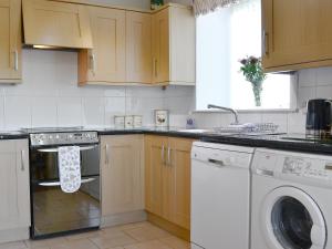 a kitchen with a stove and a dishwasher at Eliza Cottage in Haddington