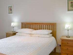a bedroom with a bed with two night stands and two lamps at Eliza Cottage in Haddington +5 photos