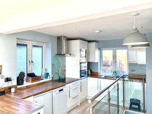 a kitchen with white cabinets and wood floors at Point Clear View in Brightlingsea