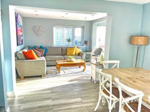 a living room with a couch and a table at Point Clear View in Brightlingsea