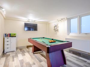 a room with a pool table and a tv at Point Clear View in Brightlingsea