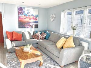 a living room with a couch and a table at Point Clear View in Brightlingsea