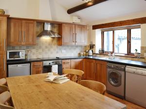 a kitchen with a wooden table with a book on it at Elm Tree Cottage in Kirkbymoorside
