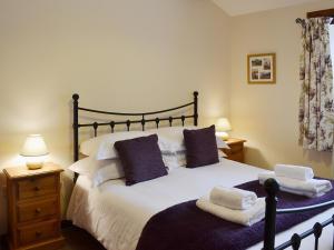 a bedroom with a large white bed with two pillows at Elm Tree Cottage in Kirkbymoorside