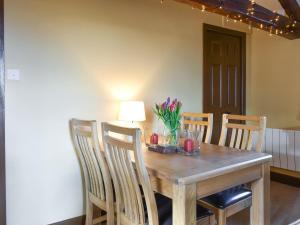 a wooden dining room table with chairs and a lamp at Timbessie Barn in Carperby