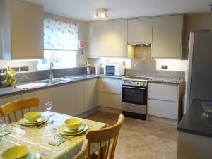 a kitchen with a table with yellow dishes on it at Bank View in Settle