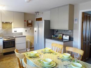a kitchen with a table and chairs and a kitchen with white cabinets at Bank View in Settle