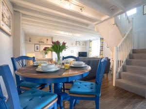 a dining room with a table and blue chairs at Cuthbert Cottage in Craster +17 photos