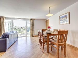 a dining room and living room with a table and chairs at 5 Red Rock Apartments in Dawlish Warren