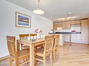 a kitchen and dining room with a wooden table and chairs at 5 Red Rock Apartments in Dawlish Warren