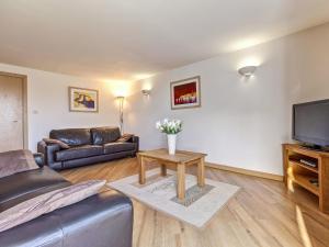 a living room with a couch and a tv at 4 Red Rock Apartments in Dawlish Warren