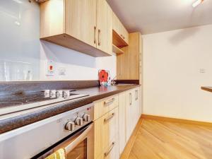 a kitchen with wooden cabinets and a counter top at 4 Red Rock Apartments in Dawlish Warren