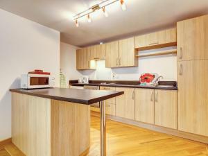 a kitchen with wooden cabinets and a counter top at 4 Red Rock Apartments in Dawlish Warren