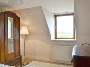 a bedroom with a window and a floor lamp at Old Post Office House in Knockbain +8 photos