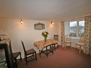 a dining room with a table and chairs and a window at Melness Cottage in Melness