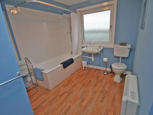 a bathroom with a tub and a sink and a toilet at Melness Cottage in Melness +2 photos