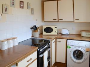 a kitchen with a stove and a microwave at Melness Cottage in Melness