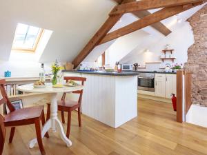 a kitchen with a table and chairs in a room at Cider Barn in Chulmleigh