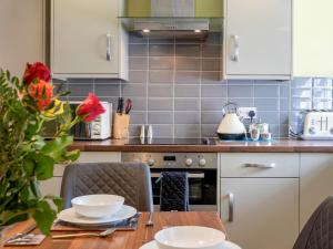 a kitchen with a table with chairs and a stove at Jame's Cottage in Keswick +16 photos