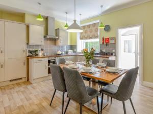 a kitchen with a dining room table and chairs at Jame's Cottage in Keswick
