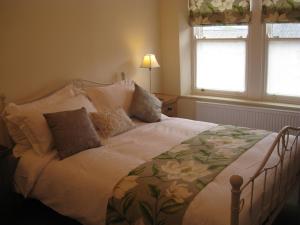 a bedroom with a large bed with flowers on it at Swallow's Nest in Bradwell