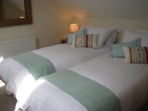 two beds sitting next to each other in a room at Swallow's Nest in Bradwell