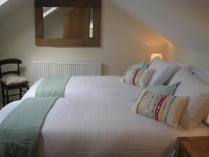 a bedroom with a large white bed with pillows at Swallow's Nest in Bradwell
