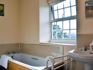 a bathroom with a bath tub and a sink at Gran's Cottage Askrigg in Askrigg +14 photos