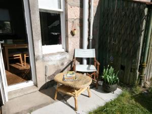 a chair and a table in front of a house at Viewington Lodge in Ballater +2 photos