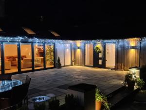 a lit up patio at night with lights at Farmhouse Cottage in North Rode +2 photos