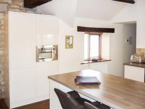 a kitchen with a wooden table and black chairs at Plum Tree Cottage in Kirkbymoorside