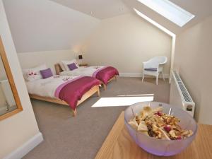 a bedroom with two beds and a bowl of food at Cairndoon Steading Whithorn in Carlton