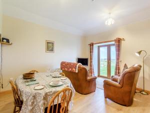 a living room with a table and chairs and a room with a window at The Barn Mey in Scarfskerry